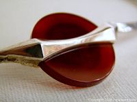 Close-up of sterling mount gripping red agate disc