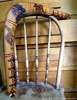 Full view of curved wooden boomerang resting on chair