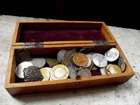Open wooden box showing interior velvet lining and assorted medals/tokens