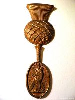 Full view of cast bronze St Andrew wall hanging showing thistle top and oval medallion