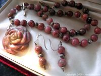 Necklace and earrings laid flat showing pendant, bead pattern, and earring design