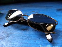 Gold-tone Tiffany & Co sunglasses on blue surface