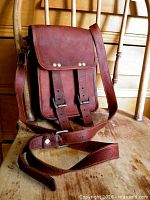 Front view of leather messenger bag on chair