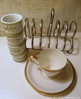 Group shot showing napkin rings stacked, cup on saucer, metal toast rack