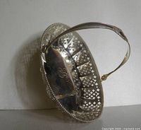 Oblique view showing pierced sides, beaded rim, handle, interior monogram