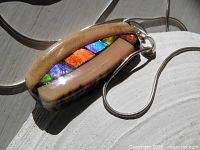 Front view showing ammolite inlay and mammoth ivory frame with attached bail