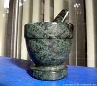 Mortar and pestle standing upright on blue surface