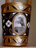 Side view of one cup showing enamel motifs and equestrian medallion