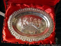 Full view of silver oval plaque in presentation box