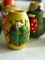 close-up of yellow barrel bead painted with green and red ladybug