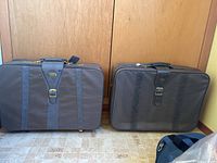 Front view of both grey Fashionlife suitcases showing size comparison, straps and buckles