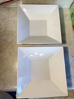 Top view of two identical white square bowls