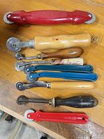 All eight tools laid out on wood surface showing handles and wheels