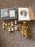 Group shot of all angel figurines, plaque and boxed items