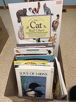 Box of animal reference and nature books headed by The Cat Wall Chart and Love Of Loons