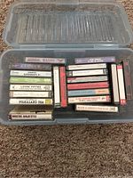 Open plastic case showing two rows of labeled audio cassette tapes
