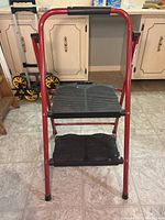 Front view of red Cosco folding step stool with two black steps