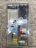 Overall view of clear case showing sanding bands, cut-off wheel vial, collet package, Sears bit package