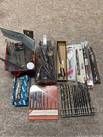 Overall lot view showing all drill bits, packaging and containers