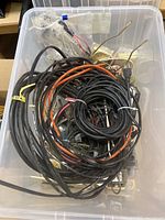 clear bin filled with assorted electrical cables, connectors, brass lamp parts