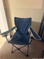 Front view of blue folding camping chair with armrests