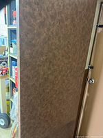 Brown laminate tabletop leaning against wall