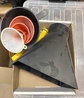Box showing extra-large black rectangular funnel, three nested red funnels, small translucent white funnel, portion of black automotive funnel