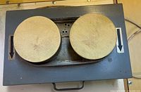 Top view of lapping machine showing two circular pads and housing