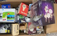 Open cardboard box showing various boxed light bulbs from Philips, GE, Valu-Bulbs and others