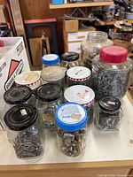 Multiple jars with assorted nails, screws, nuts visible