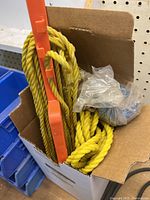 Box containing yellow polypropylene ropes, orange plastic winder, clear bag with blue rope