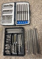 Open blue/white and black cases showing assortment of bits