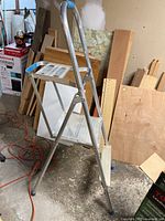 Full view of aluminium two-step ladder folded open in workshop