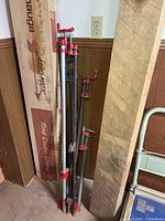 Group of six pipe clamps leaning against wall