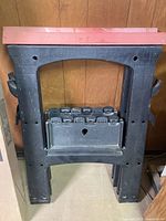 folded black plastic sawhorse showing full frame and shelf