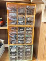 Full view of orange and green plastic storage cabinet showing all drawers filled with hardware