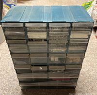 Front view of blue plastic 27-drawer organizer filled with assorted hardware