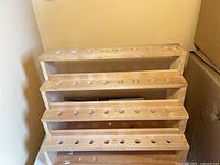 Front view of five-tier wooden stand showing drilled holes