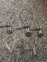 Six calipers and divider laid out on carpet for full view