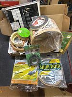 Multiple rolls of veneer edging, grip tape, foam weatherseal inside box