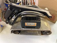 Left side view of Craftsman Commercial belt sander showing handle, motor housing and belt area