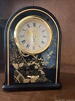 Full view of black and gold floral mantel clock