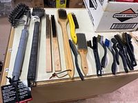 Full group of eleven wire brushes laid out on tabletop