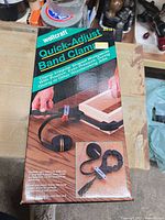 Retail box front showing product name and image of clamp in use