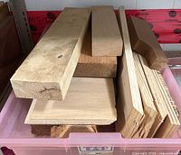 Bin containing mixed hardwood boards of varying sizes