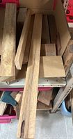 Several hardwood offcuts and strips in cardboard tray on shelf
