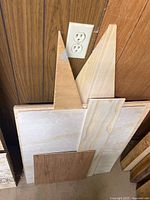 Assorted wood pieces leaning against wall showing variety of shapes