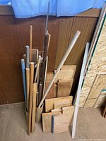 bundle of dowels and board pieces leaning against wall