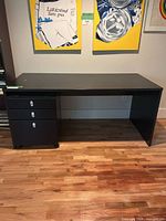 Front view of black desk with pedestal underneath