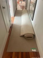 Both rugs in hallway, runner laid flat, area rug rolled